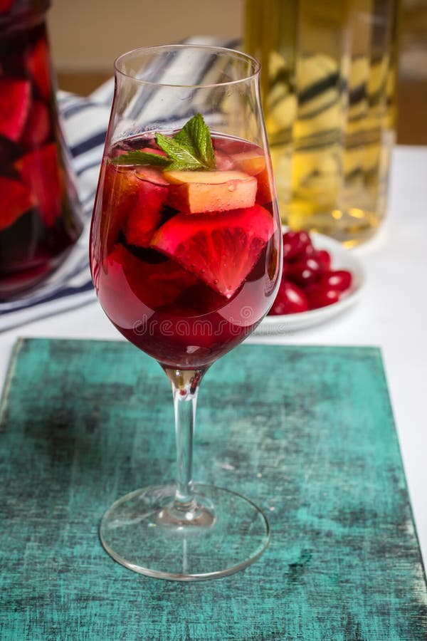 Summer sangria cocktail in wine glass , plate with dogwood berries