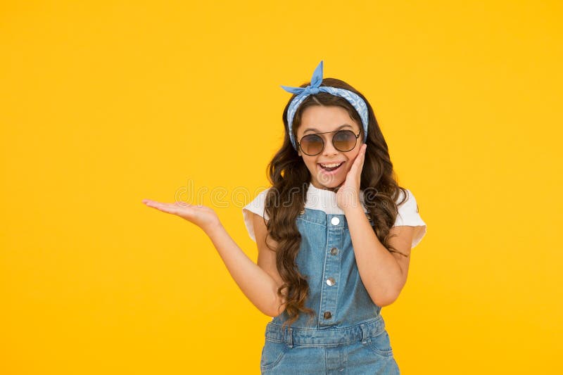 Summer shopping sales. pin up kid. happy childrens day. cheerful vintage girl on yellow background. little beauty presenting product. love her retro fashion style. summer vacation.