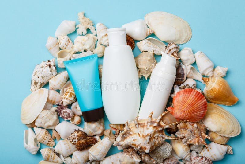 Summer skin care cosmetics, panama and sunglasses on blue background