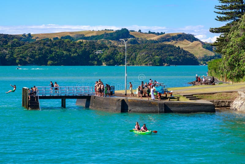 Raglan, New Zealand. People swimming and boating from pier