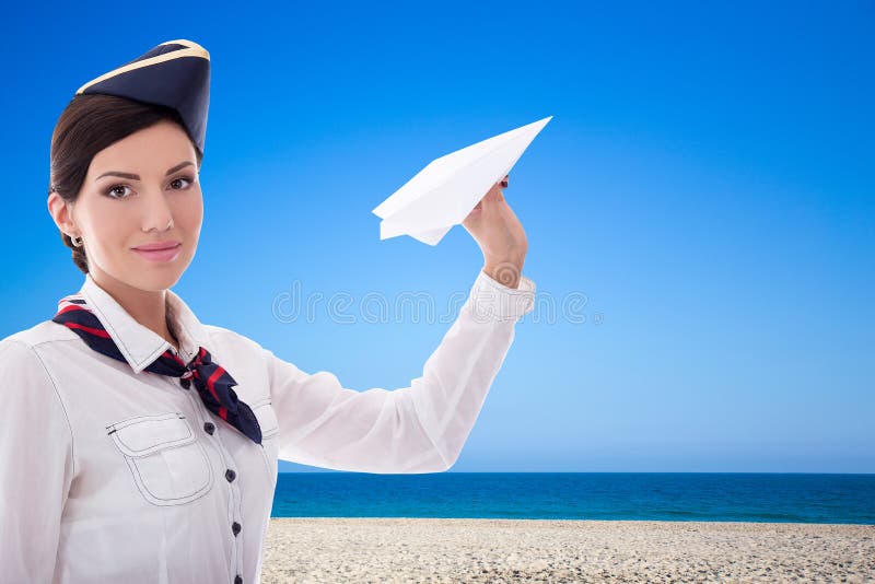 Summer and travel concept - stewardess with paper plane over beach background royalty free stock image Summer and travel concept - stewardess with paper plane over beach background royalty free stock image