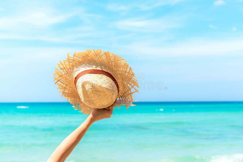 Summer Travel. Happy and Relax woman hand holding big hat on white sand beach