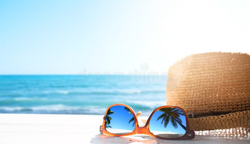 Summer tropical beach background; glasses and palm tree reflex