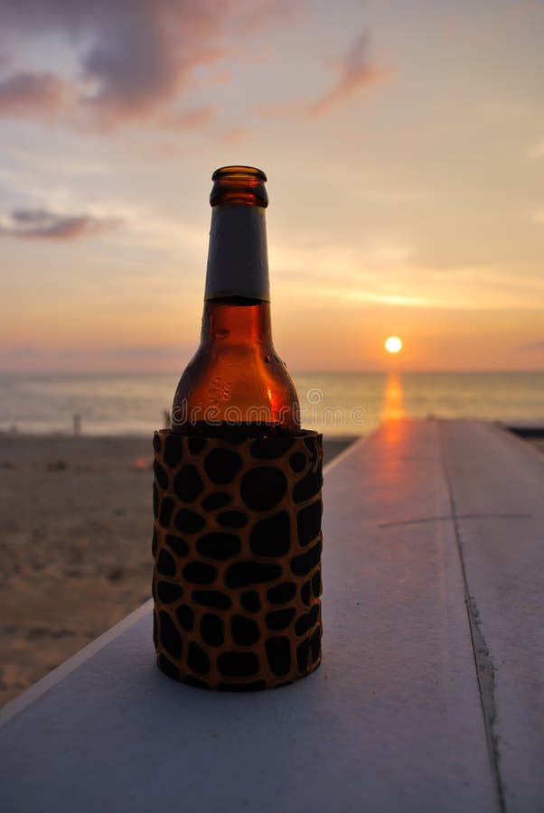 In a Summer Vacation. Bottle of Beer on the Beach at Sunset Stock Image