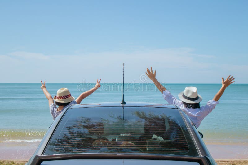 Family car trip at the sea, Woman and child cheerful raising their hands up and feeling happiness.