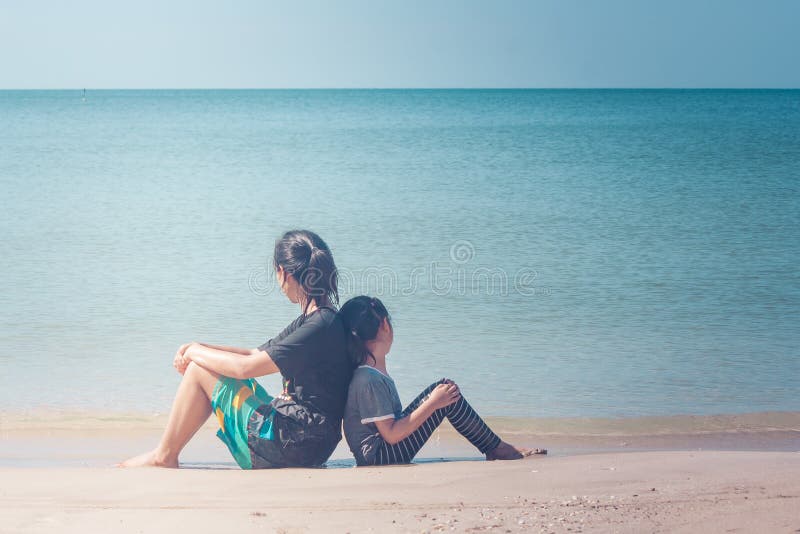 Summer Vacation and Holiday Concept : Happy family day trip at the sea, Woman and child sitting back to back relax on sand beach. stock image Summer Vacation and Holiday Concept : Happy family day trip at the sea, Woman and child sitting back to back relax on sand beach. stock image