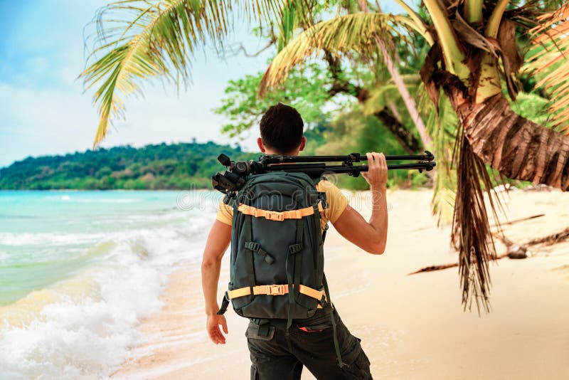 Summer vacation, Travel and LifeStyle concept: photographer with camera in hand taking photo on the beach on background nature