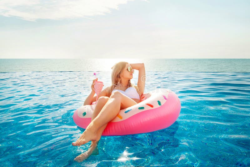 Summer Vacation. Woman in bikini on the inflatable donut mattress in the SPA swimming pool.