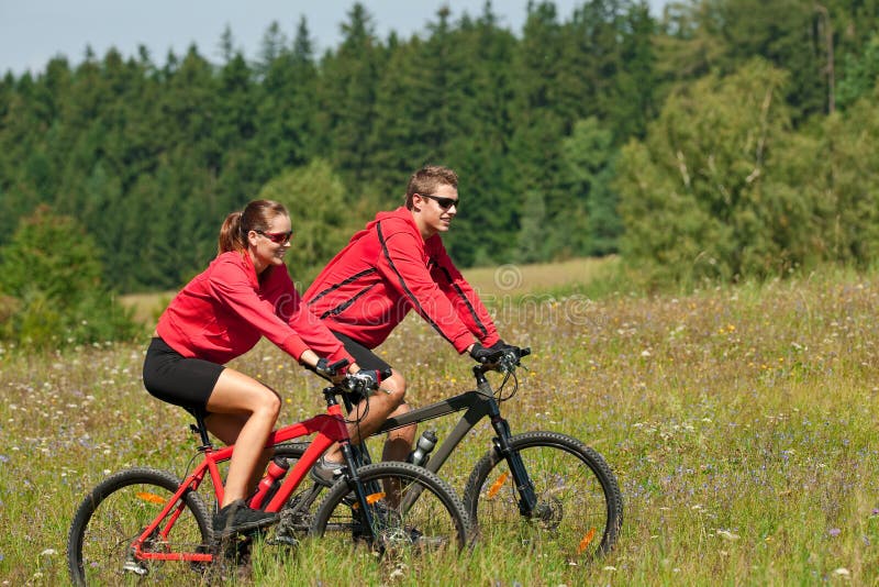 Summer - Young couple riding bike in summer stock photo Summer - Young couple riding bike in summer stock photo