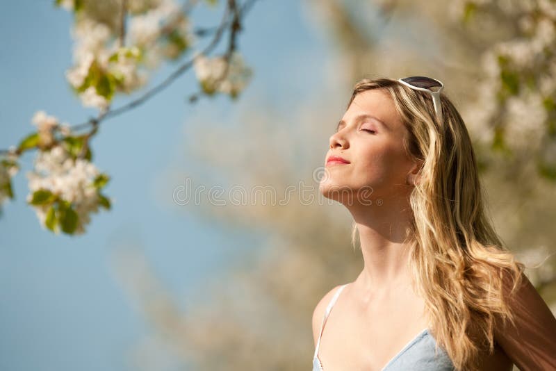 Summer - young woman under blossom tree