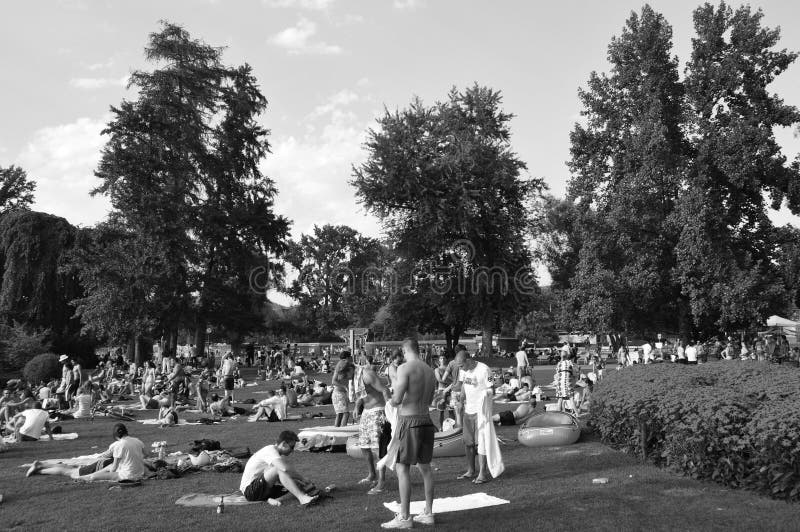 Summertime: people in Zürich Seefeld lake promenade and park are taking a sun bath. Or a swim in the lake. Not anymore But due to Corona Covid19 virus stock photo Summertime: people in Zürich Seefeld lake promenade and park are taking a sun bath. Or a swim in the lake. Not anymore But due to Corona Covid19 virus stock photo