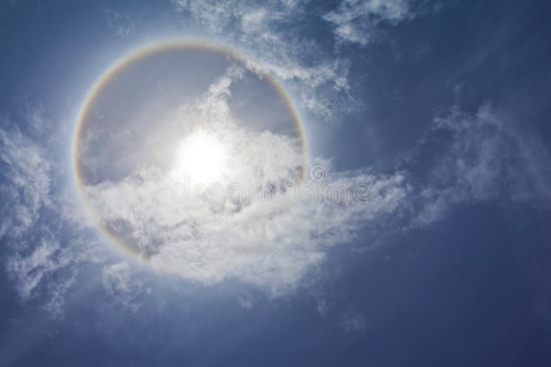 Sun with circular rainbow, clouds and blue sky. Sun with circular rainbow, clouds and blue sky