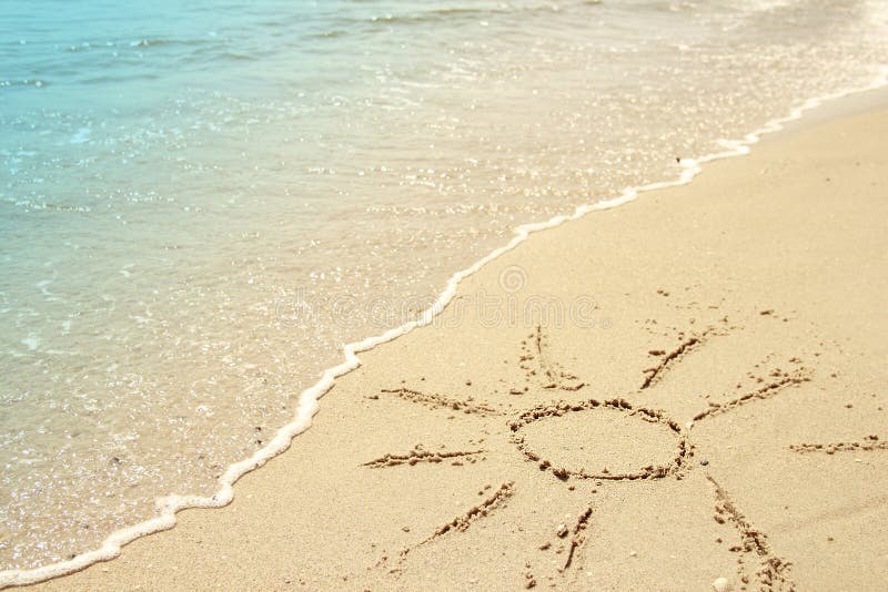 Sun drawn in the sand on the seashore royalty free stock image