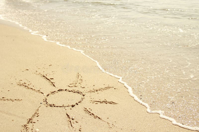 Sun drawn in the sand on the seashore stock photos