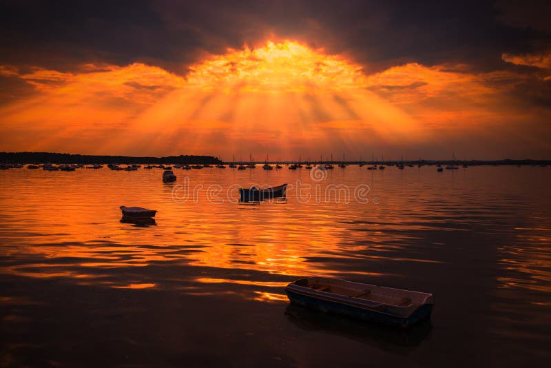 Sun rays illuminate boats in Poole Harbour stock photos