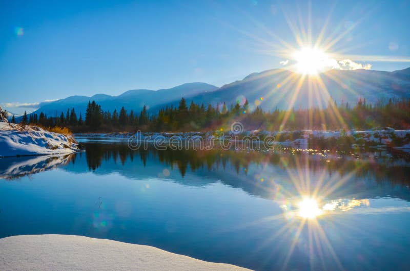 Sun flare reflection winter landscape. River, mountains.