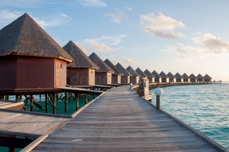 The sun rise over water bungalows in amazing water villas