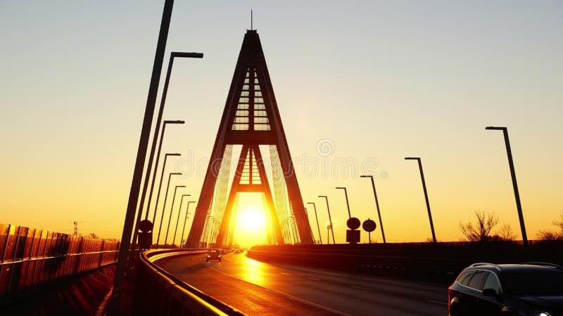 The sun rises while morning rush hour traffic on the Bridge