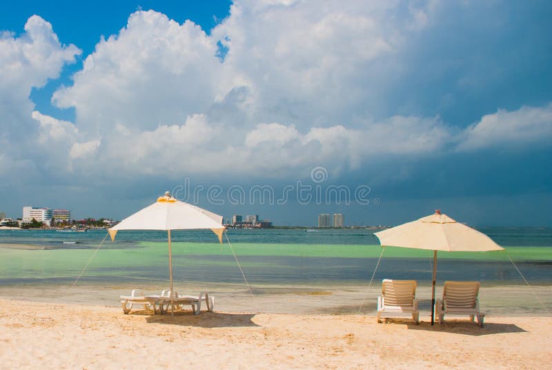 Sun-Ruhesessel und -regenschirme für Touristen auf dem Strand in Cancun, Mexiko lizenzfreie stockfotografie Sun-Ruhesessel und -regenschirme für Touristen auf dem Strand in Cancun, Mexiko lizenzfreie stockfotografie