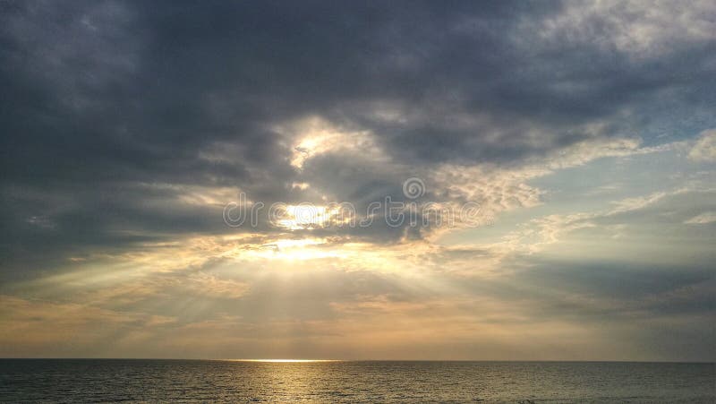 The sun s rays piercing the clouds above the sea. HDR photo representing lead clouds over Bucharest