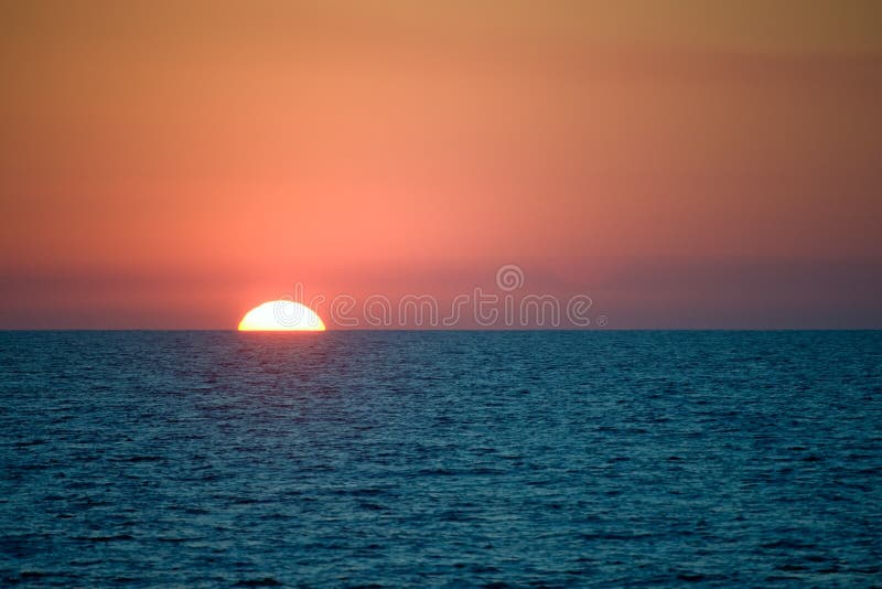 Sun setting behind sea horizon royalty free stock photos Sun setting behind sea horizon royalty free stock photos