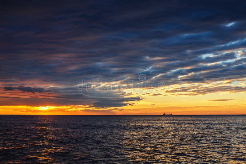Sun setting at the sea with sailing cargo ship, scenic view royalty free stock images Sun setting at the sea with sailing cargo ship, scenic view royalty free stock images