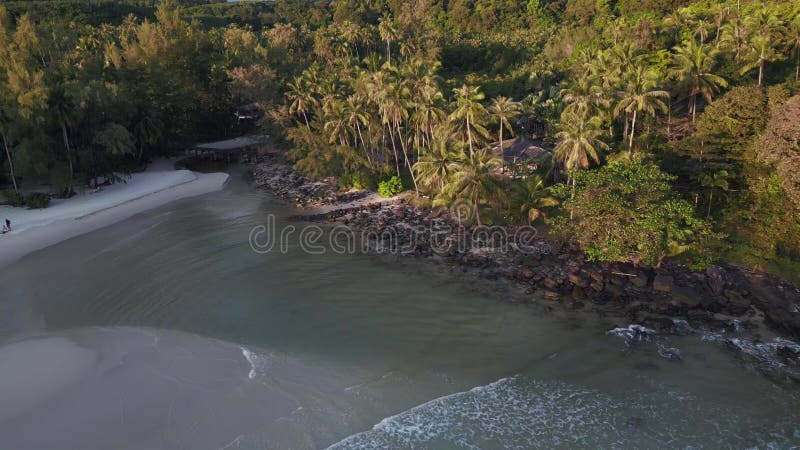 Sun shines beach house palm trees on hill. Unbelievable aerial view flight drone