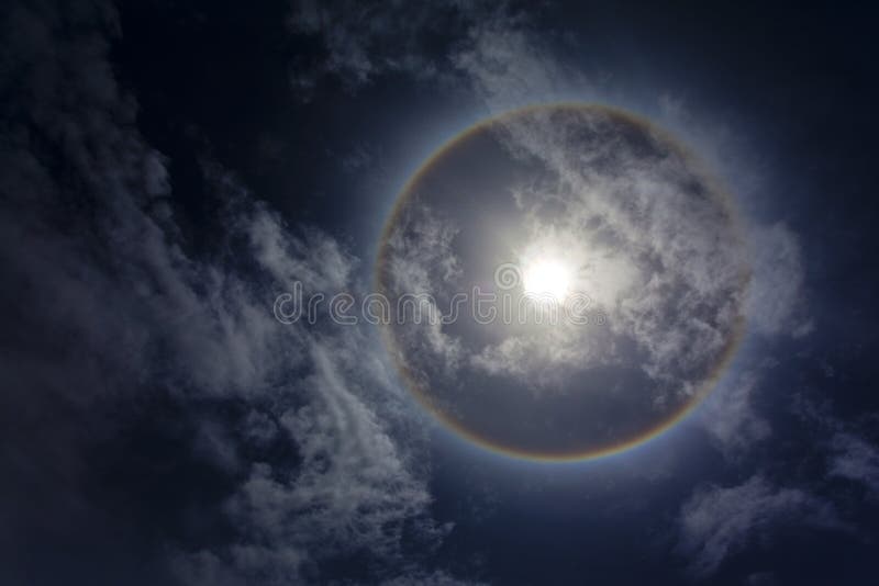 Sun with circular rainbow, clouds and blue sky. Sun with circular rainbow, clouds and blue sky