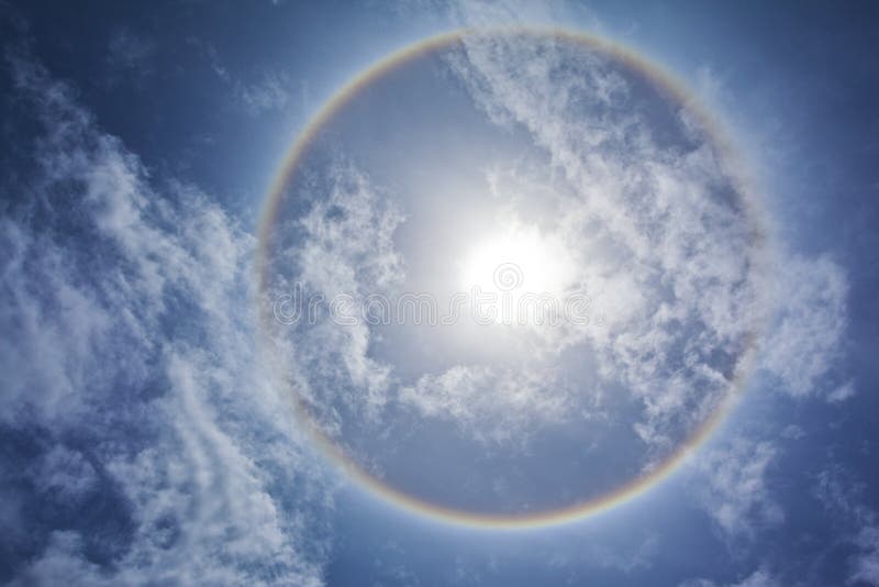 Sun with circular rainbow, clouds and blue sky. Sun with circular rainbow, clouds and blue sky