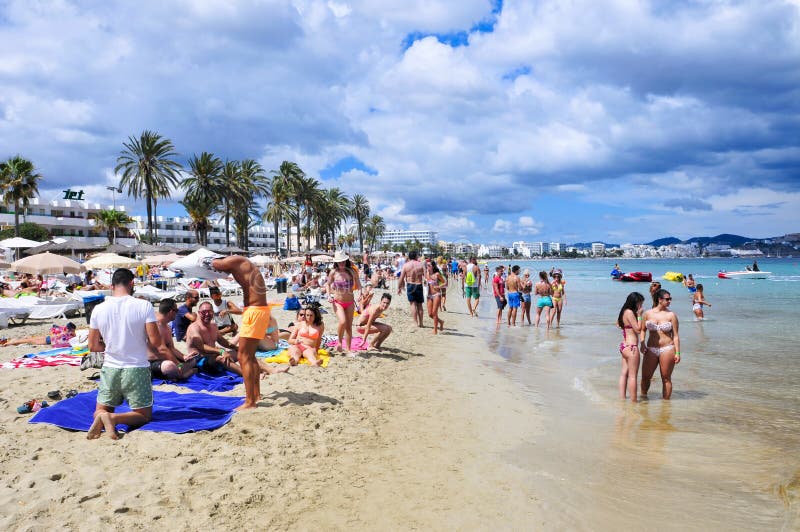 Sunbathers in Platja den Bossa beach in Ibiza Town, Spain. 