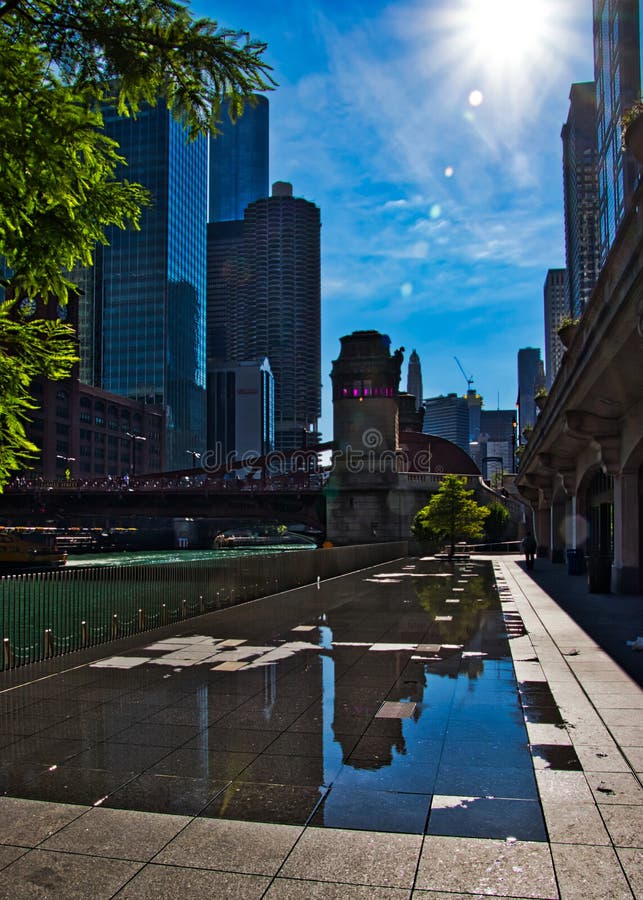 Sunbeams Extend Over Splash Pad with Reflections of Cityscape on
