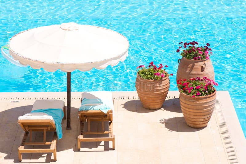 Sunbeds en paraplu dichtbij de pool Sunbeds en paraplu dichtbij de pool