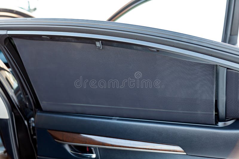 Sunblind on the glass of the rear door of the car black color close-up protects from the sun rays. Sunblind on the glass of the rear door of the car black color close-up protects from the sun rays