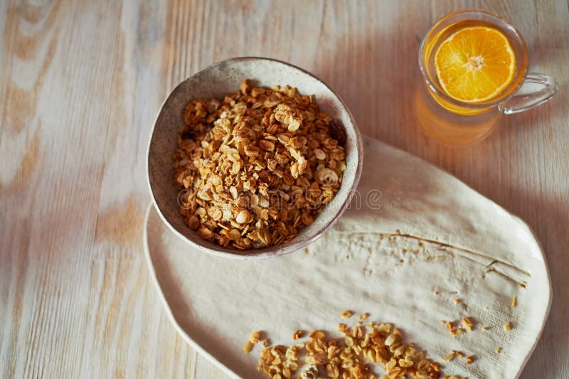 Sund frukost av mästare Mysli ett exponeringsglas av vatten med en skiva av apelsinen Keramiskt handgjort royaltyfria bilder Sund frukost av mästare Mysli ett exponeringsglas av vatten med en skiva av apelsinen Keramiskt handgjort royaltyfria bilder