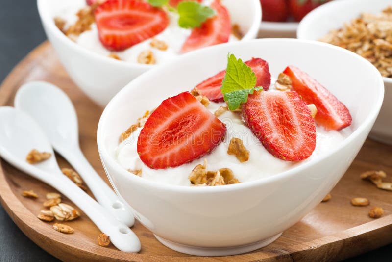 Sund frukost - yoghurt med ny jordgubbar och granola royaltyfria bilder Sund frukost - yoghurt med ny jordgubbar och granola royaltyfria bilder