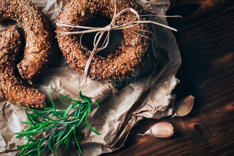 Sund organisk hel kornbagel på trätabellen brödfrukosten äter mellanläggsmedelsnabba korvmellanmål till royaltyfria bilder Sund organisk hel kornbagel på trätabellen brödfrukosten äter mellanläggsmedelsnabba korvmellanmål till royaltyfria bilder