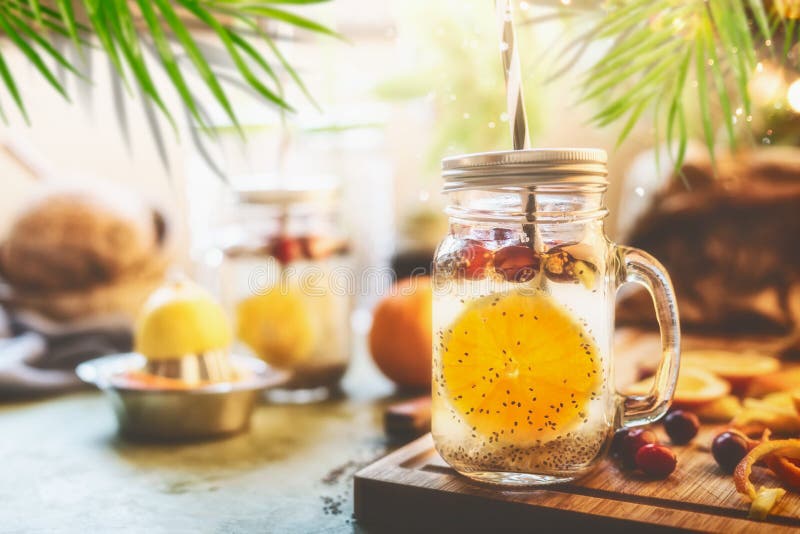 Sund sommardryck med vatten för Chia frödetox, orange frukter skiva, citronjuice och tranbär i murarekrus med på arkivfoto