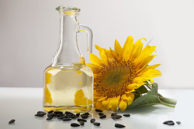 Sunflower Oil in a Transparent Jug with Sunflower Flower.. Stock Image