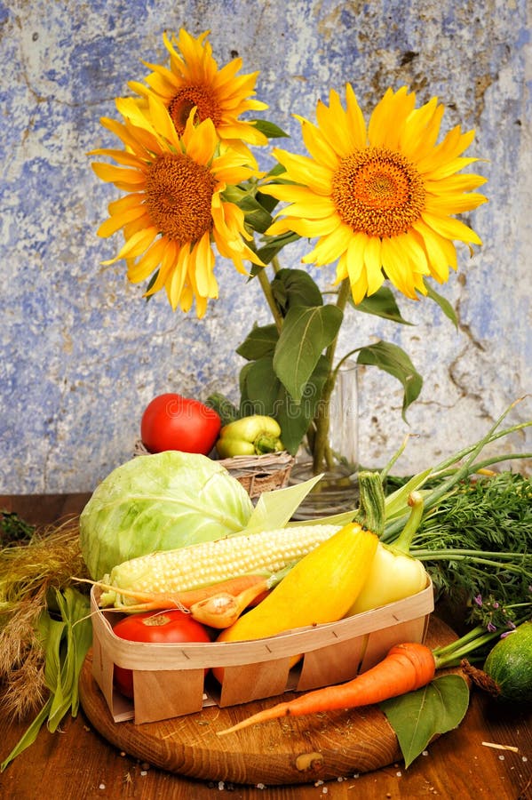 Sunflowers bouquet and assorted fresh vegetables in a basket stock image Sunflowers bouquet and assorted fresh vegetables in a basket stock image