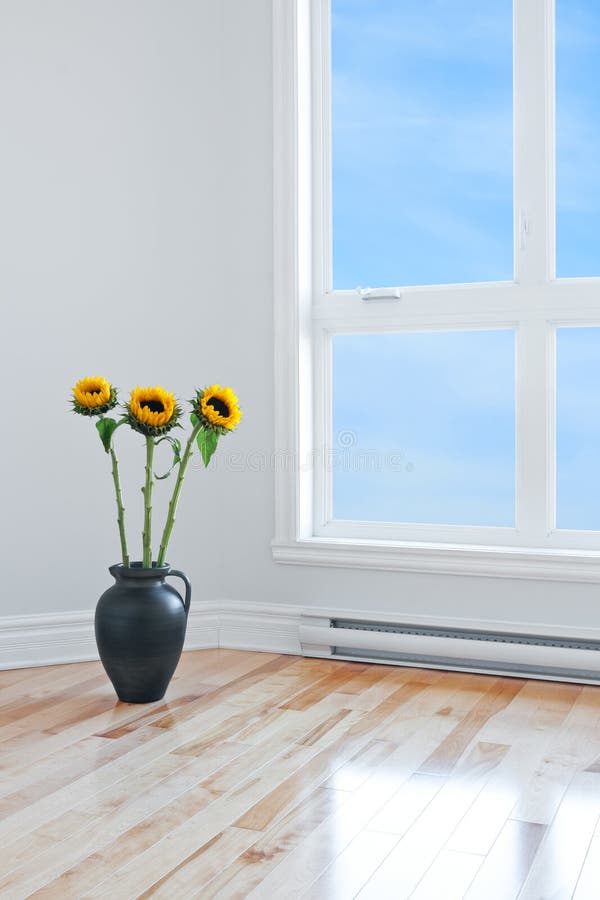 Sunflowers in empty room with big window