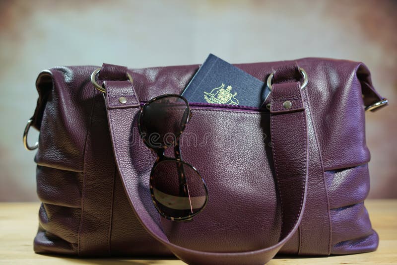 Sunglasses and passport in purple carry bag