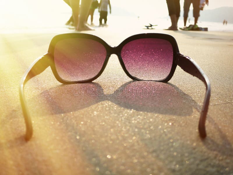 Sunglasses on the sand stock photo. Image of evening 53542384
