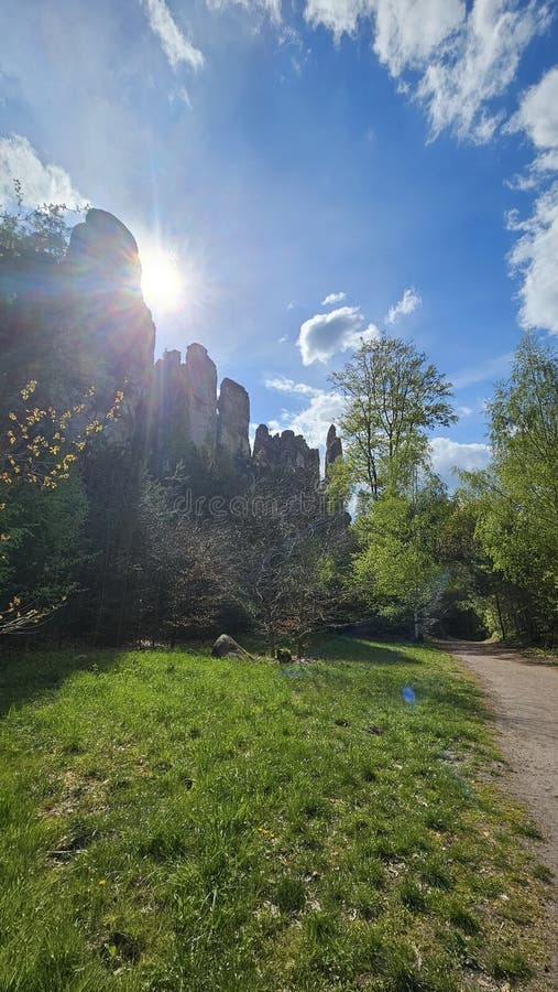 Sunlight shines brightly over a landscape dominated by towering rock formations and scattered trees royalty free stock photography