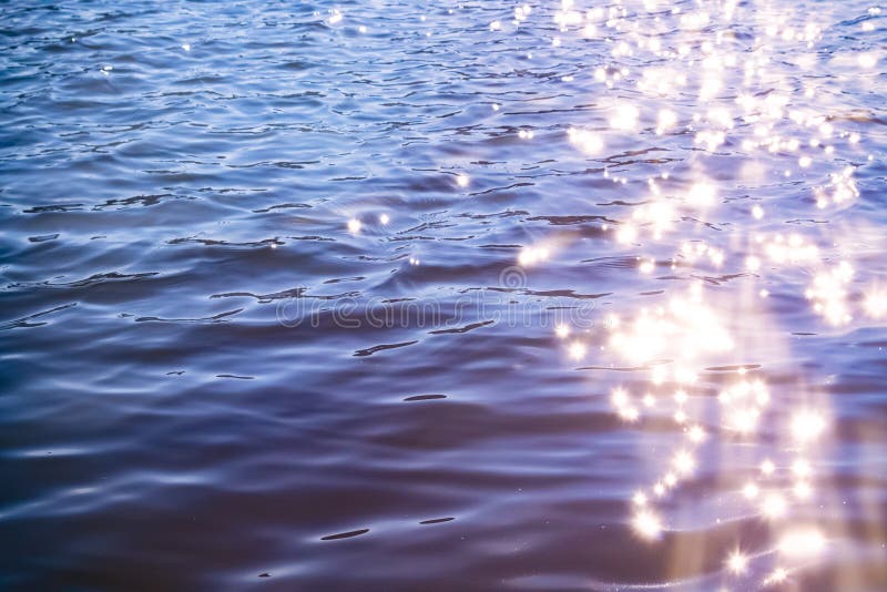 Sunlight twinkling off river water with small waves. Calm summer