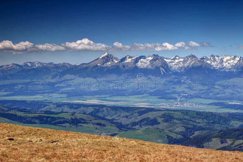 Sunlit snowy Tatra peaks and green forests in spring Slovakia