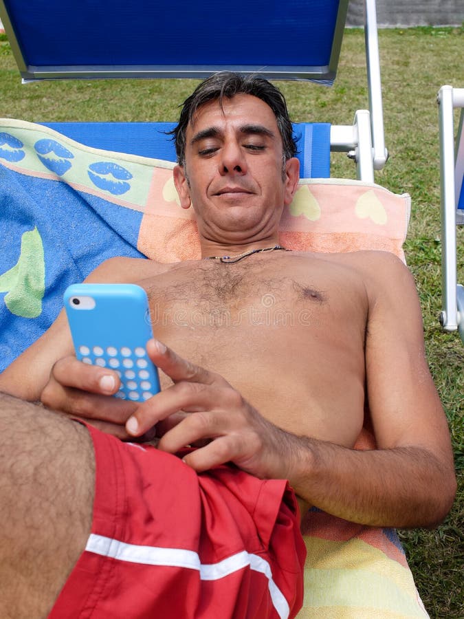 On sunlounger with smartphone stock photo On sunlounger with smartphone stock photo