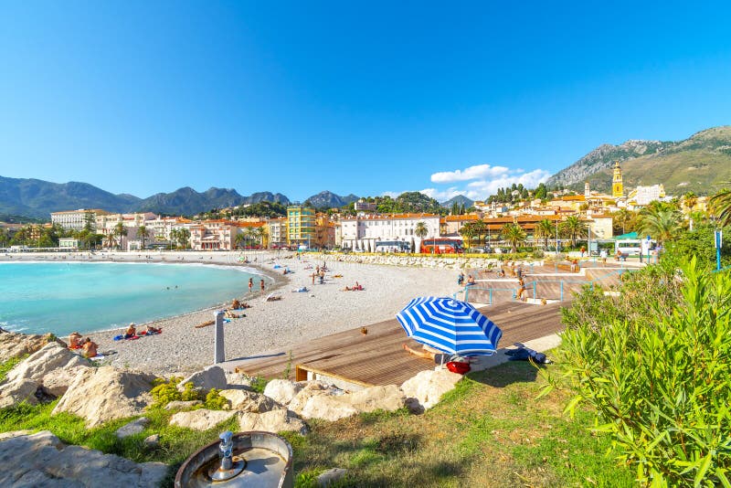 A sunny day on the French Riviera as they relax on the sandy Plage de Fossan Mediterranean beach in Menton, France royalty free stock photography A sunny day on the French Riviera as they relax on the sandy Plage de Fossan Mediterranean beach in Menton, France royalty free stock photography