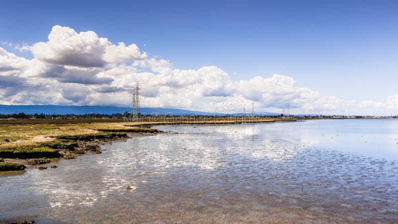 Sunny day on the shoreline of San Francisco Bay; white cumulus clouds reflected on the shallow marsh waters; Palo Alto, California stock images Sunny day on the shoreline of San Francisco Bay; white cumulus clouds reflected on the shallow marsh waters; Palo Alto, California stock images