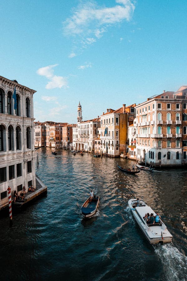 A Sunny Day in Venice with Boats and Gandolas Floating through Canals ...