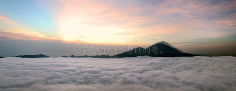 Panorama of Sunrise above clouds with a mountain volcano view. Mt. Batur Bali Indonesia